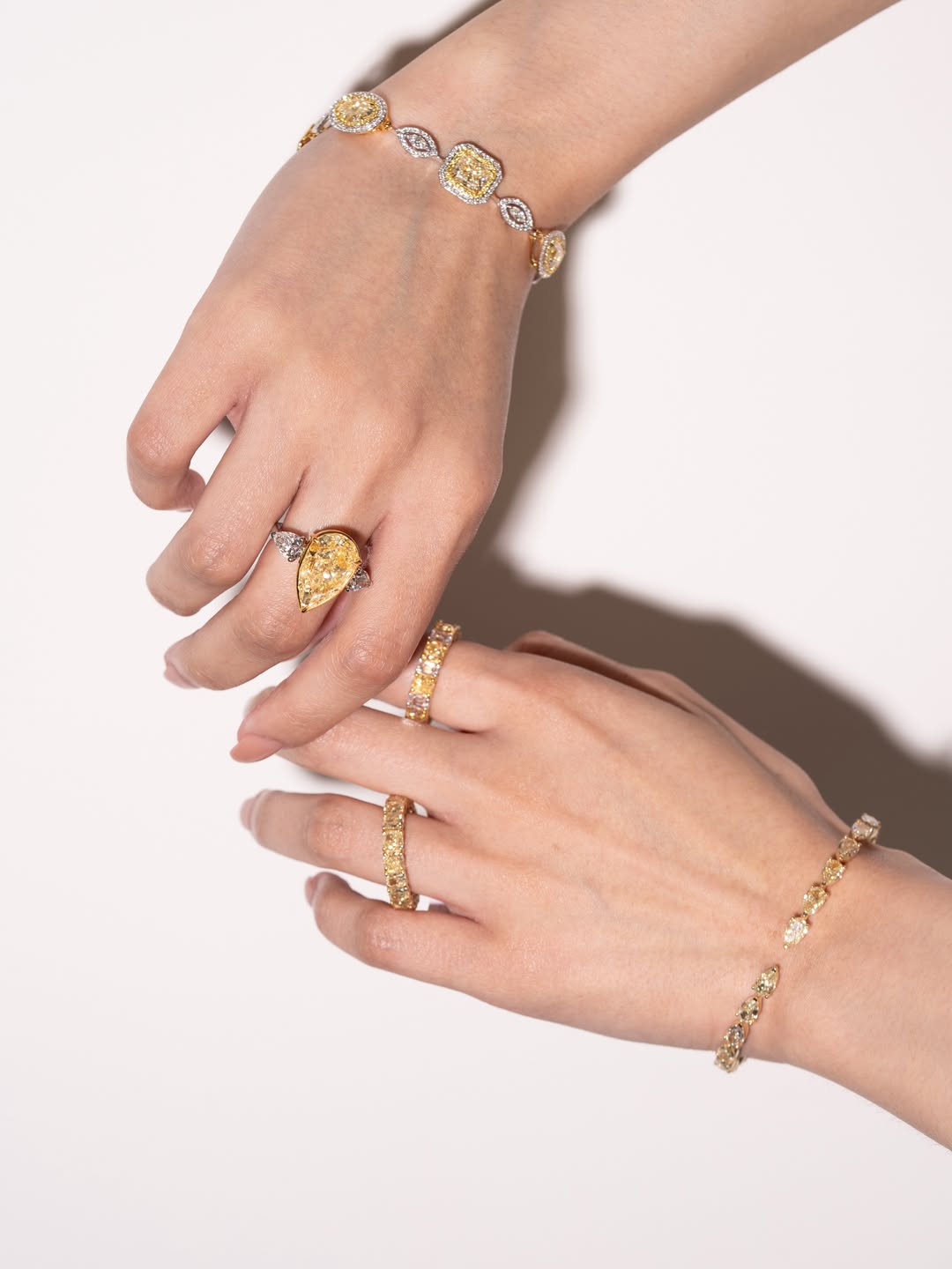 Yellow diamond rings and bracelets on hands